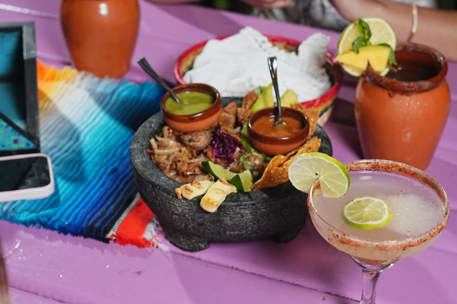 Molcajete con carnes, salsas de la casa, tortillas recién hechas y cócteles